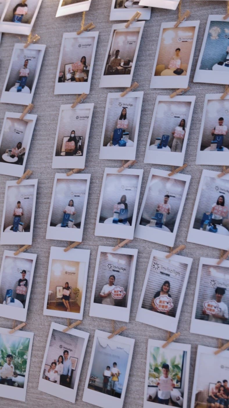 A wall of patient Polaroid photos at The Garden Dental